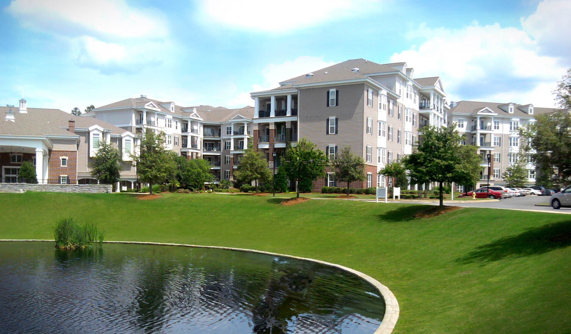 Comunidade de senior living com jardins, lago e áreas de convivência